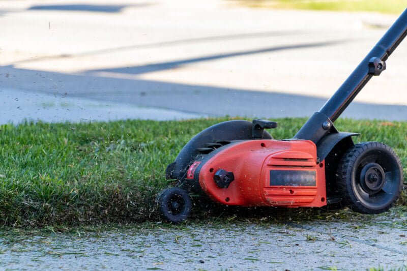 Grass flying in the air after being cut by an edger