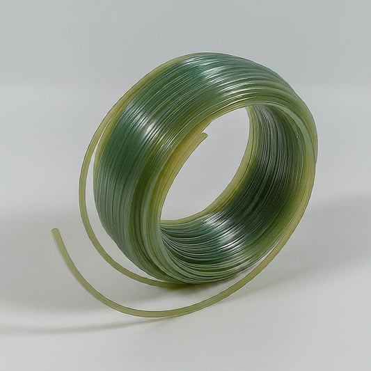A roll of green plastic tubing on a white surface, perfect for string trimmer line