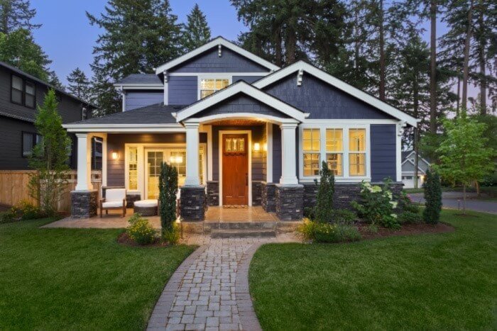 Residential house with a pristine, well-maintained front yard, illustrating the results of using a grass trimmer and a lawn mower.