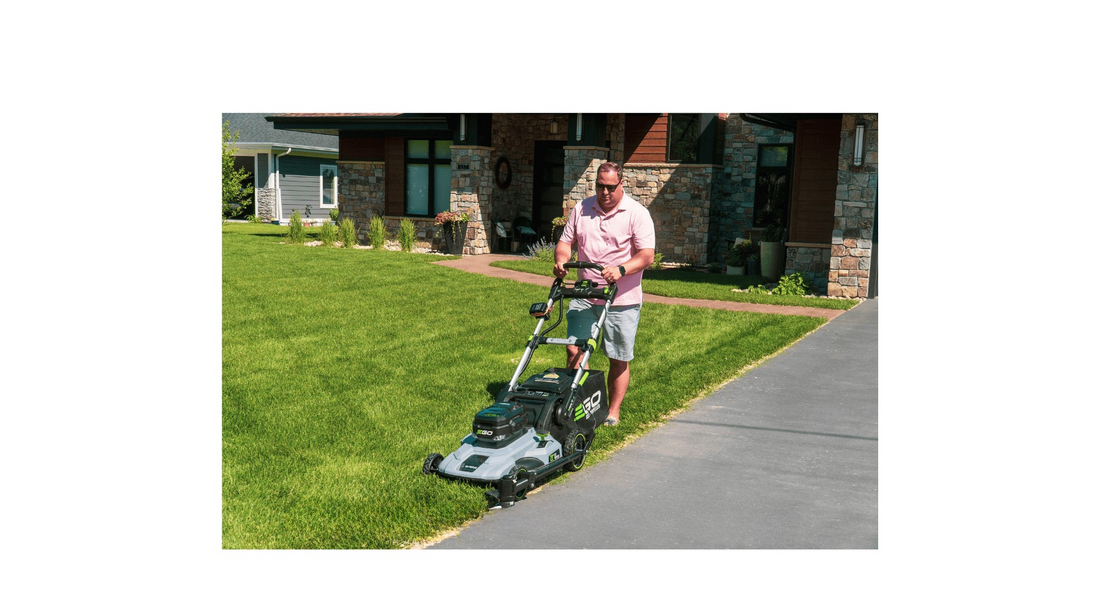 Man edging the lawn with the push lawn mower and the Trimyxs attached