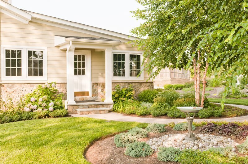 A pristine, perfectly mowed front lawn, demonstrating the ideal outcome when learning how to mow a lawn for beginners