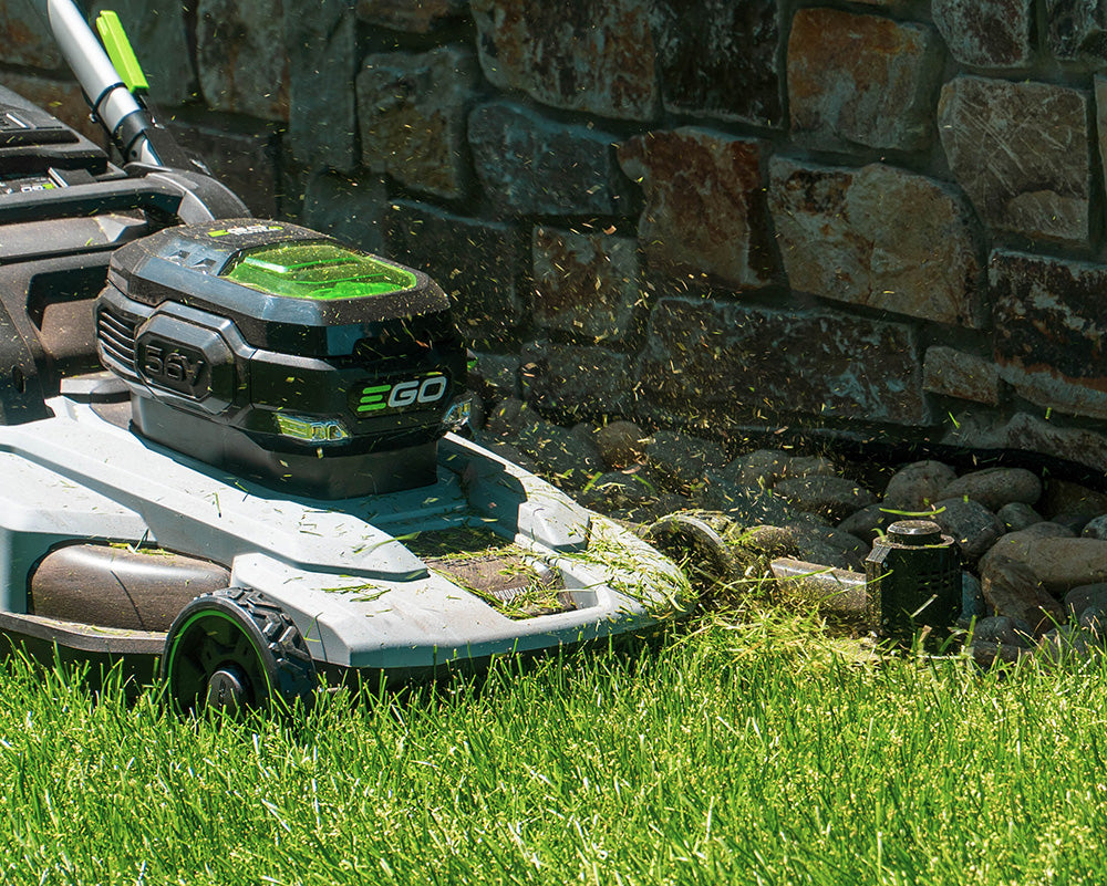 an Ego brand push lawn mower with the Trimyxs attached in action