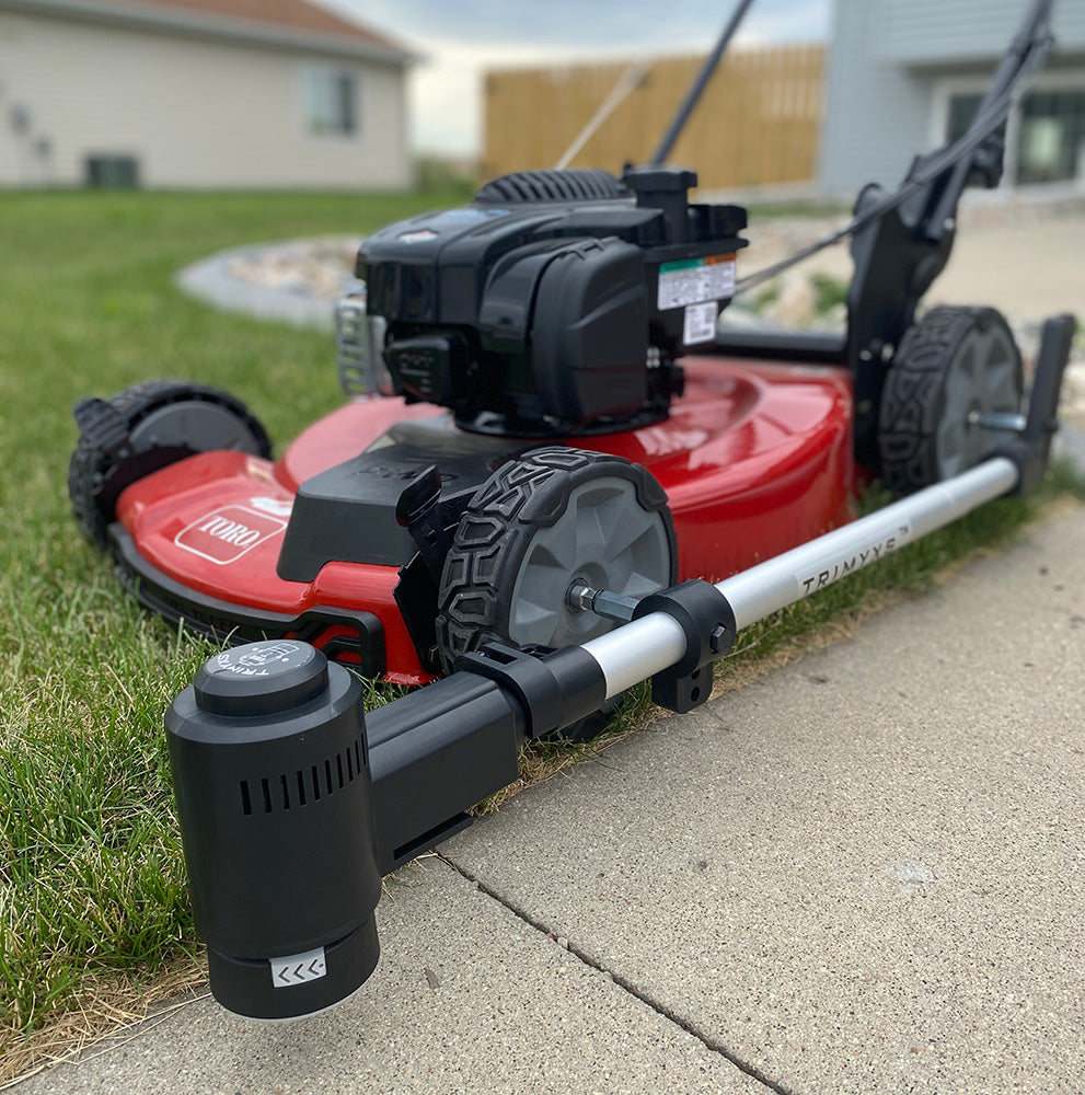 A close-up of the Trimyxs attachment attached to the red push lawn mower