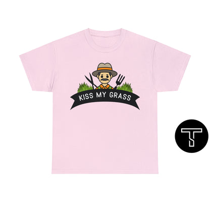 A light pink t-shirt with phrase "kiss my grass" and an image of a man holding a two lawn care tools