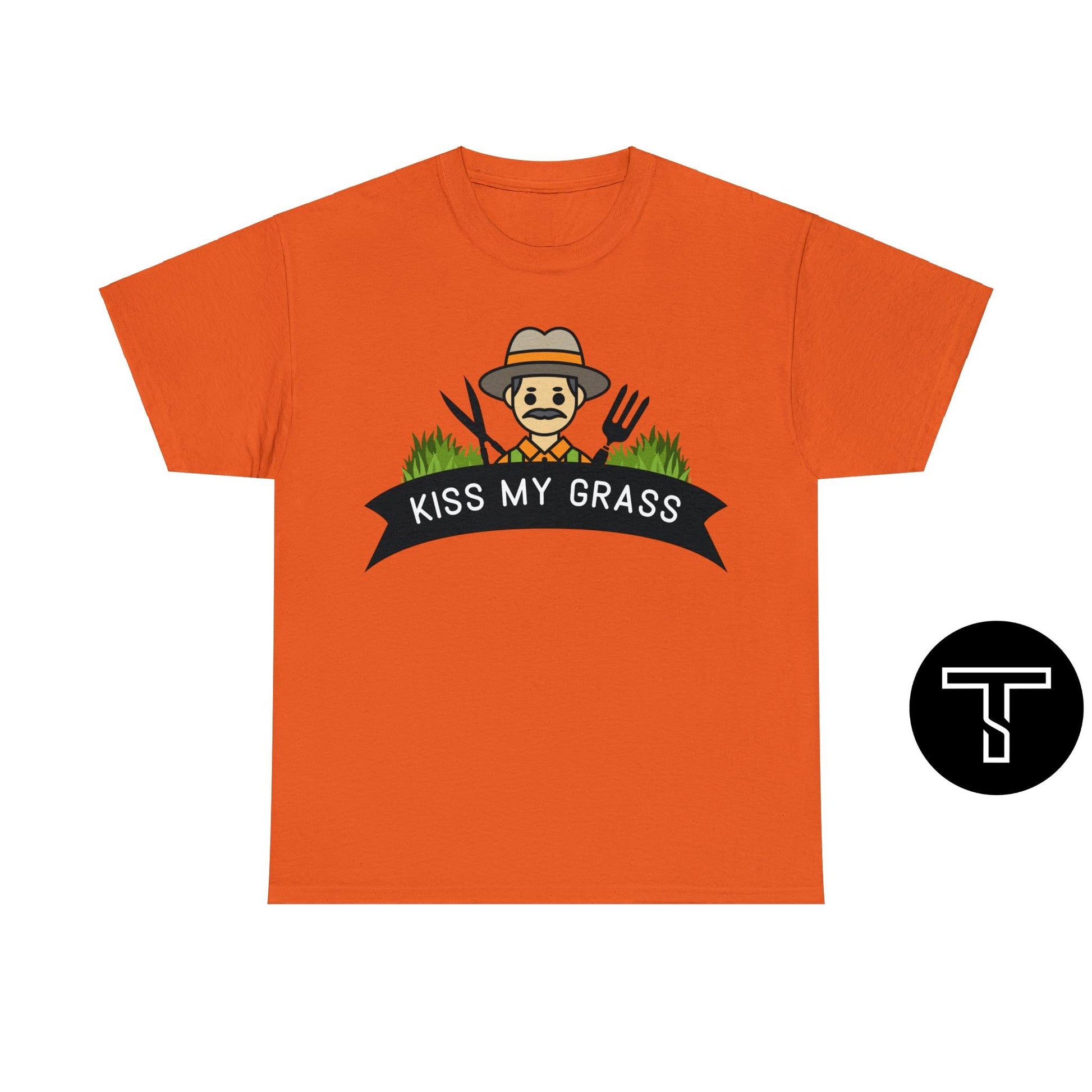 A orange t-shirt with phrase "kiss my grass" and an image of a man holding a two lawn care tools