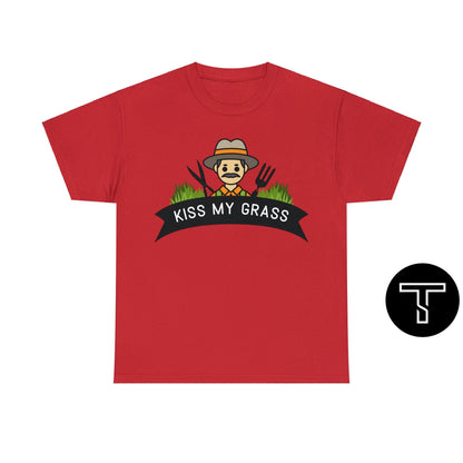 A red t-shirt with phrase "kiss my grass" and an image of a man holding a two lawn care tools